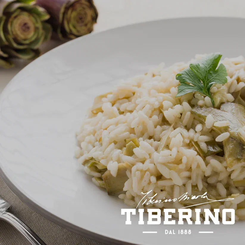 Close-up of creamy artichoke risotto garnished with fresh parsley on white plate