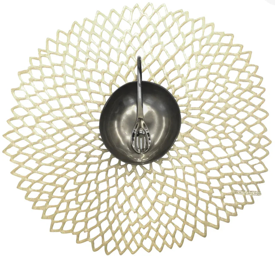 decorative brass finish placemat with small metal bowl and spoon on top