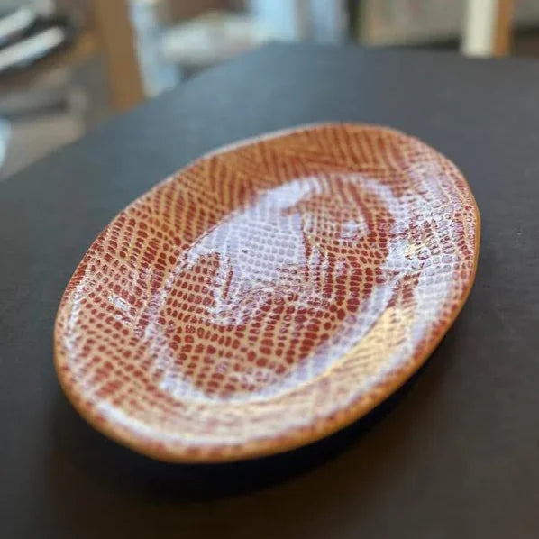 Decorative tray with a white pattern on a dark surface
