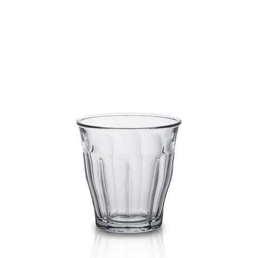 Empty clear ribbed glass tumbler with thick base on white background
