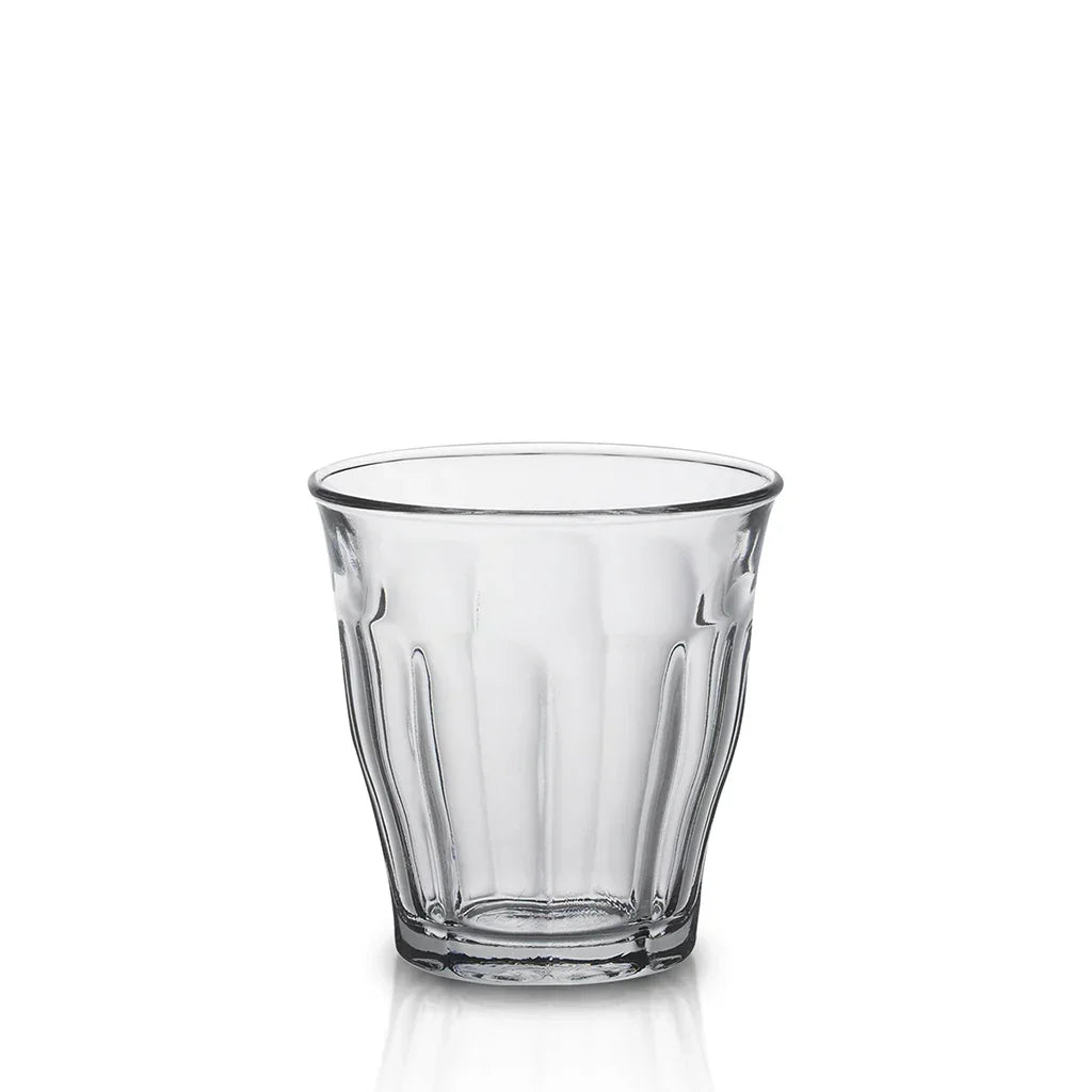 Clear empty faceted glass tumbler on white background
