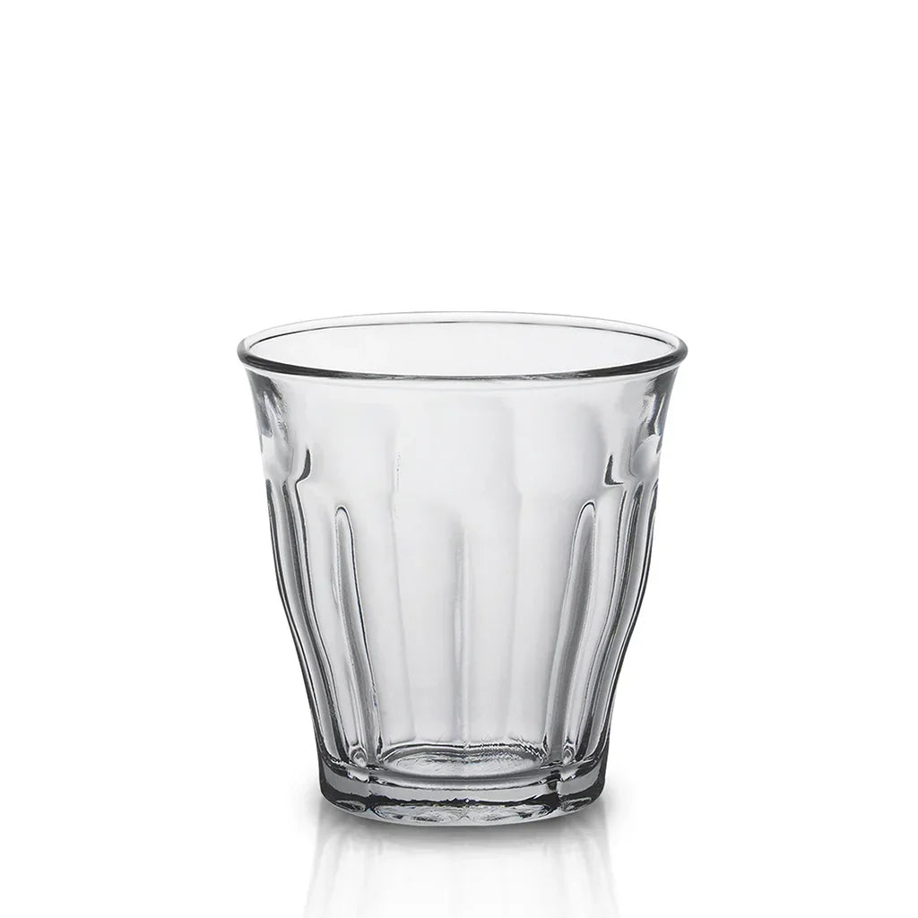 Clear vintage-style glass tumbler with fluted sides on white background