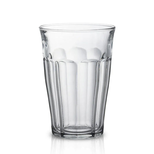 Clear faceted drinking glass with vertical ridges on white background