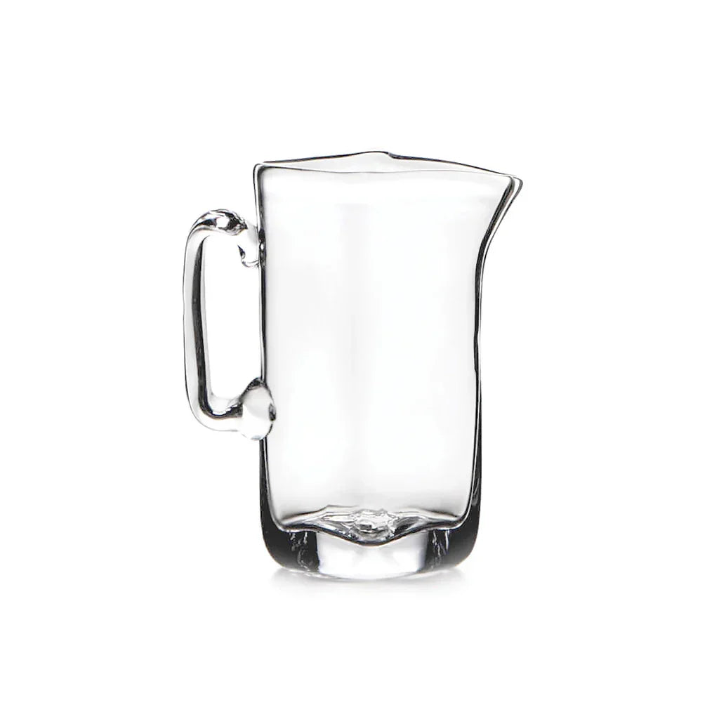 Clear glass pitcher with handle and spout on white background