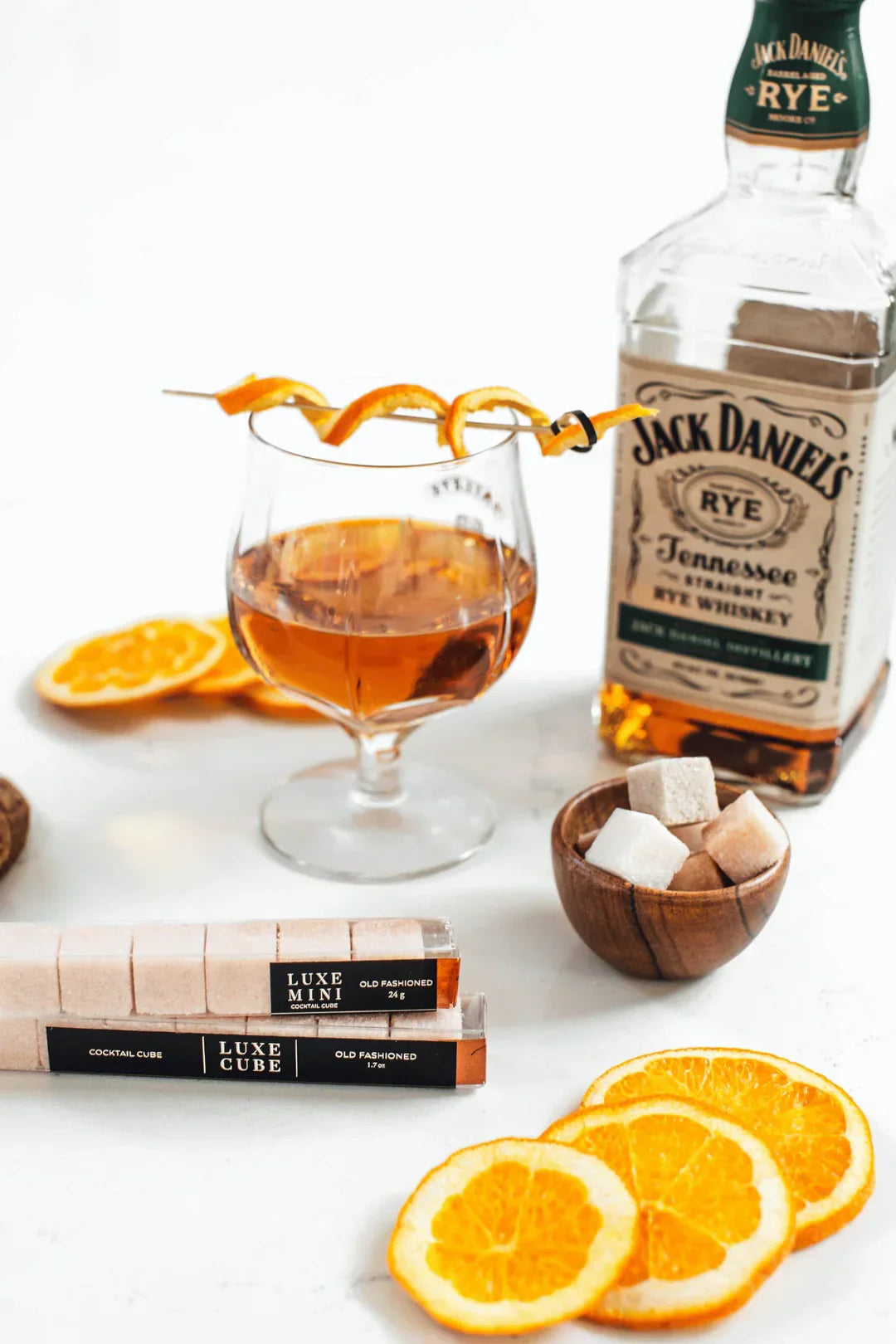 Old Fashioned cocktail with orange peel garnish, Jack Daniel's Rye whiskey, sugar cubes, and dried orange slices