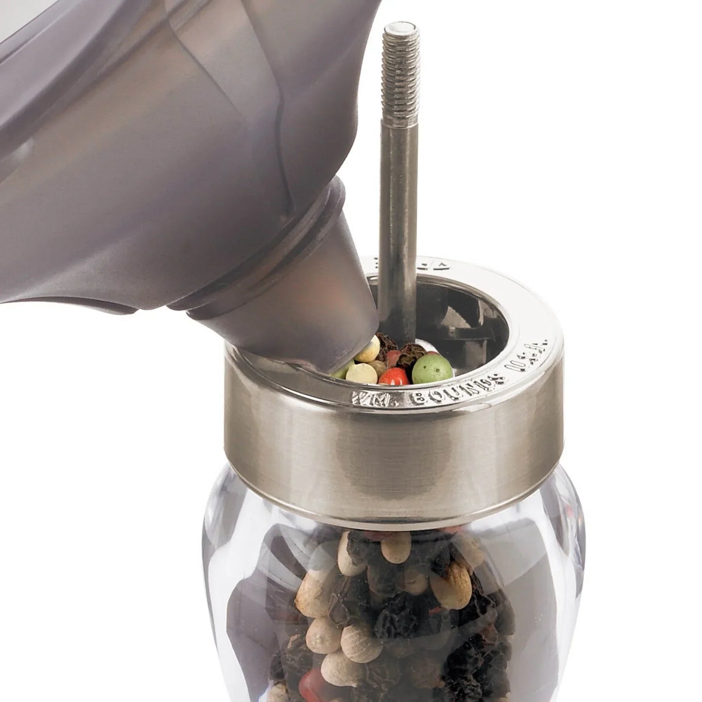 Filling glass and stainless steel pepper grinder with mixed peppercorns from a gray funnel