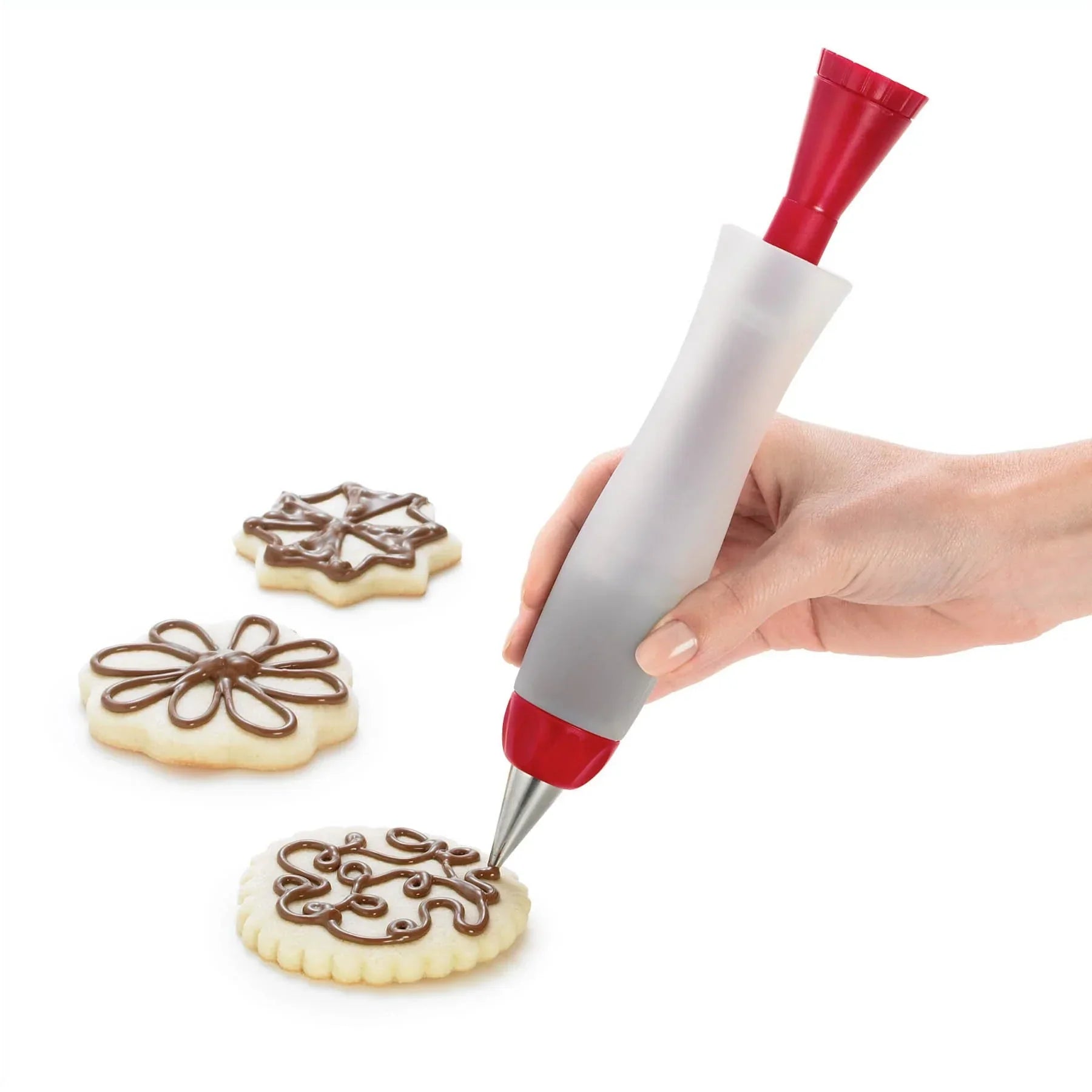 Hand decorating sugar cookies with chocolate using a red and white icing pen