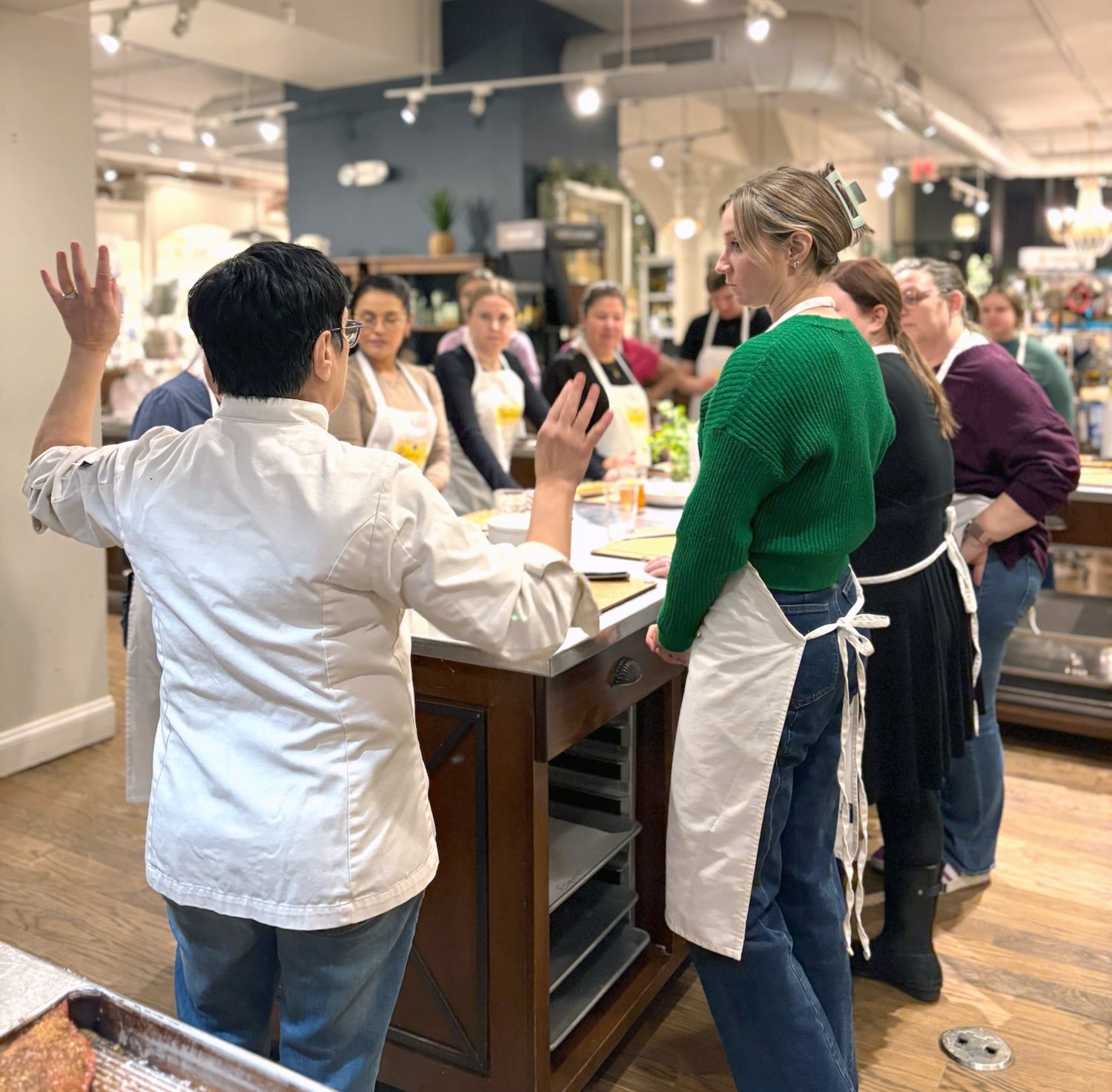 Corporate team building cooking competition at Marcel's Culinary Experience — teams collaborating to create dishes under chef-led instruction