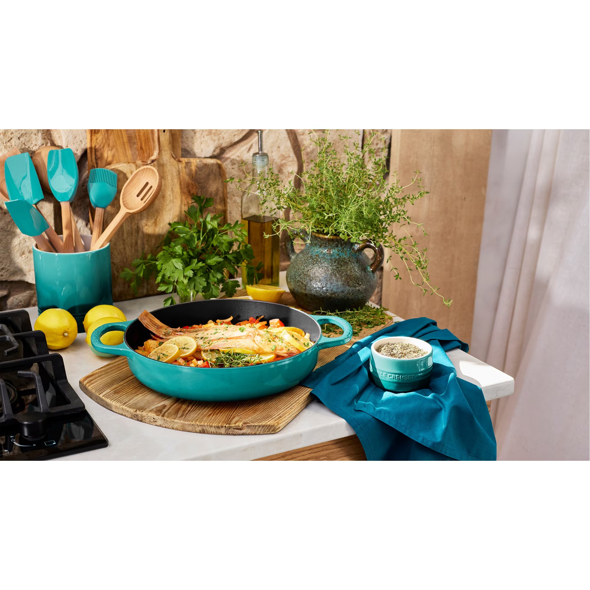 Teal Le Creuset cookware on a kitchen counter with food and utensils | Marcel's 