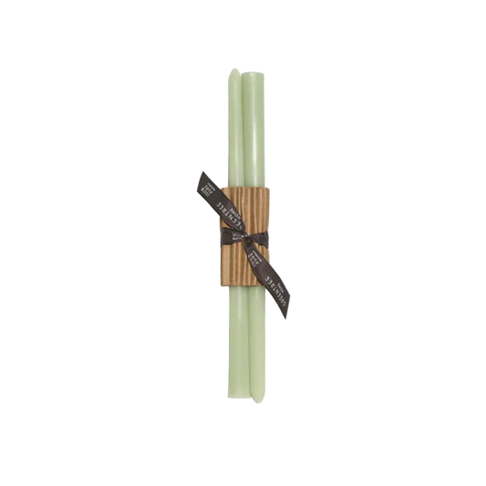 Two green candles tied with a brown ribbon on a white background