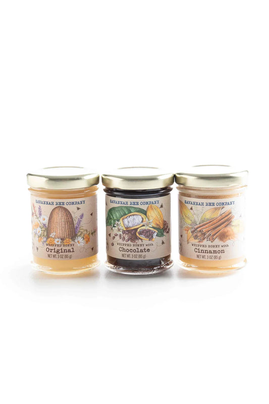 Three 3oz jars of Savannah Bee Company whipped honey in Original, Chocolate, and Cinnamon flavors with illustrated labels