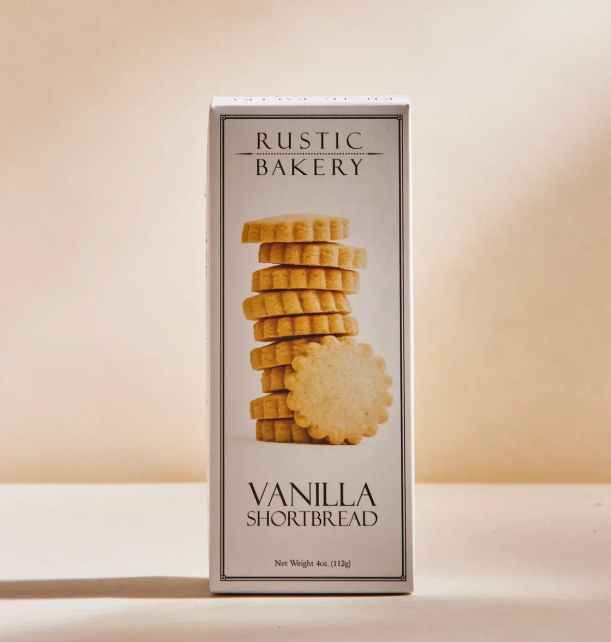 Rustic Bakery Vanilla Shortbread box with a stack of shortbread cookies on beige background