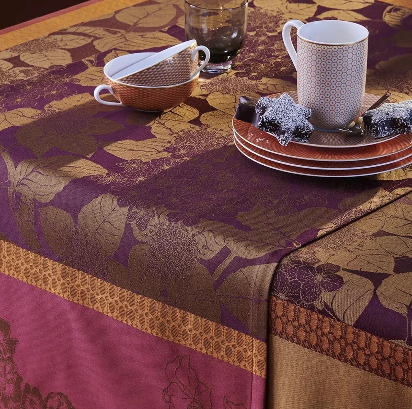 garnier thiebaut jacquard table runner 61 x 100 inches in deep purples, deep pinks, golds, and pumpkin orange colors with a pattern of hydrangeas and leaves