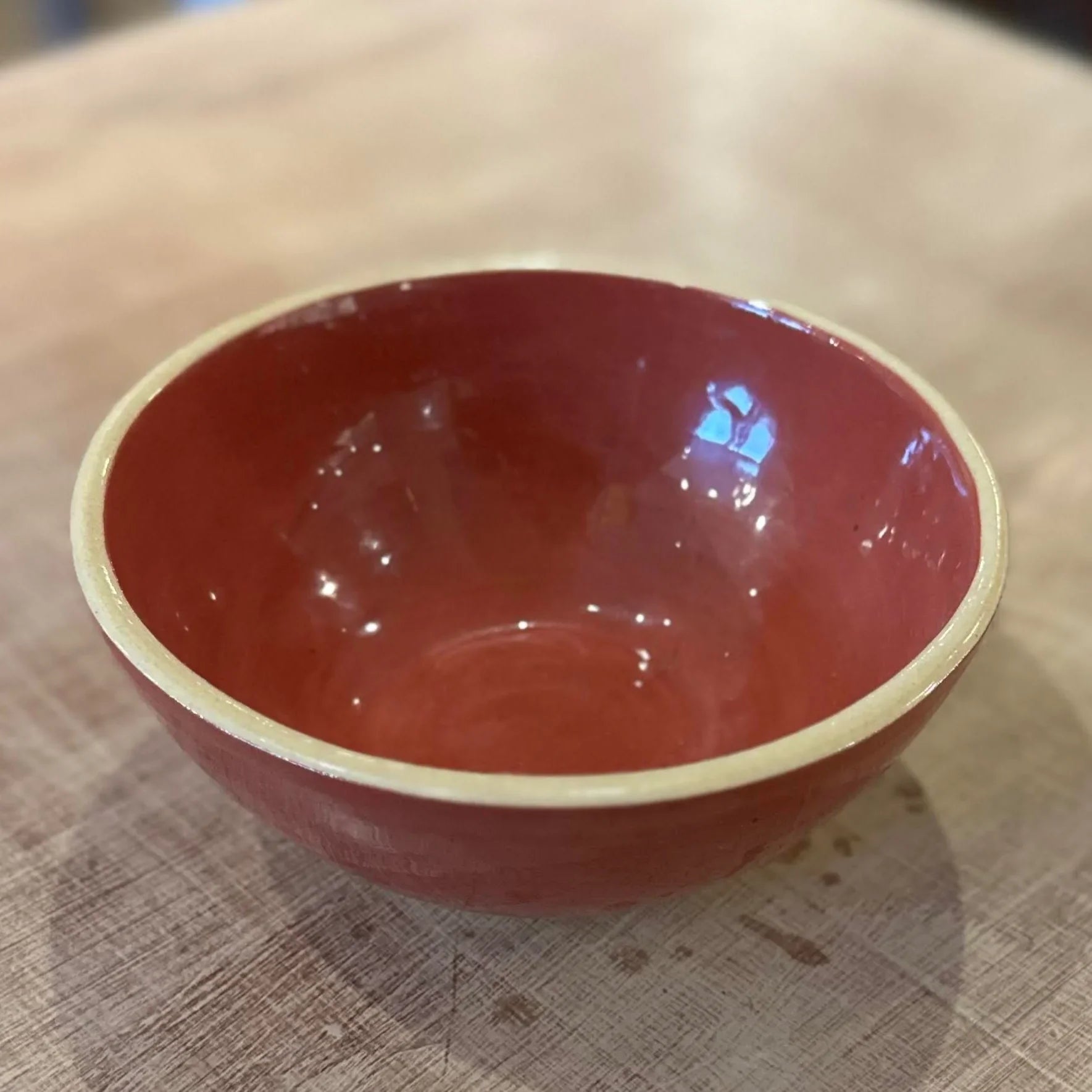 rust red ceramic bowl on a textured surface