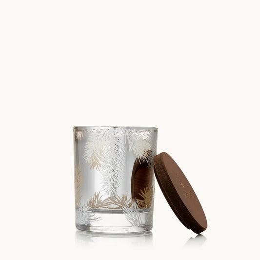 Clear glass candle holder with white and gold pine needle design and a dark wooden lid